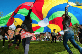 Students having fun with a colorful parachute on Pangy Day